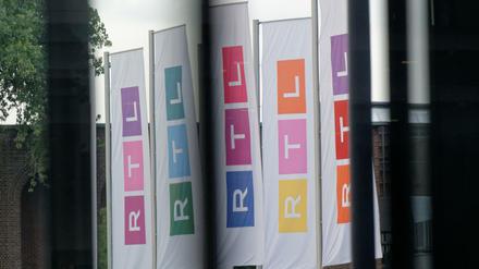Fahnen des Fernsehsenders RTL stehen auf dem Platz vor dem Firmengebäude.