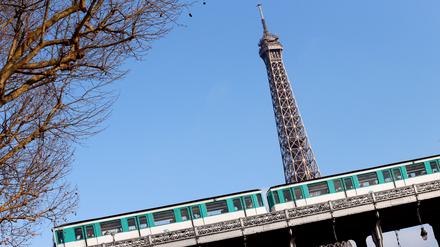 A picture taken on November 28, 2012 shows a train driving in front of the Eiffel Tower on an elevated railroad between the "Bir-Hakem" and the "Passy" metro stations in Paris. AFP PHOTO / PATRICK KOVARIK