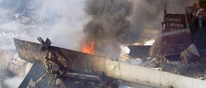 Die brennenden Wrackteile des abgestürzten Flugzeugs; ein russisches Modell des Typs Antonov.
