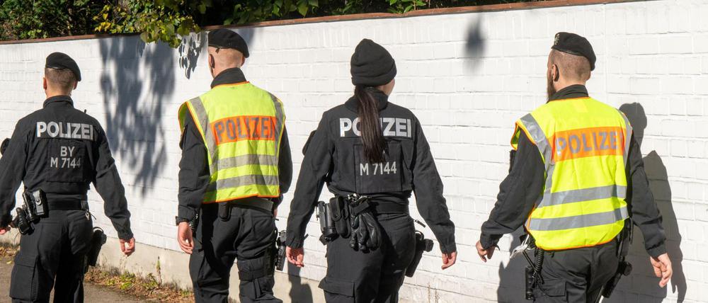 Polizisten gehen im Münchner Stadtbezirk Bogenhausen auf einer Straße entlang. Hier ist ein 14-jähriges Mädchen tot aufgefunden worden.