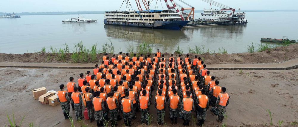 Rettungskräfte und Soldaten versammeln sich vor dem Jangtse-Fluss in China. Das Schiff "Eastern Star" wurde komplett geborgen und wird an Land geschleppt. Bei der Katastrophe kamen 434 Menschen ums Leben.