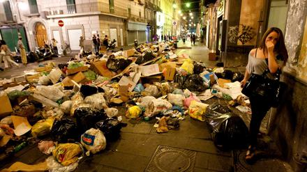 Eine Bewohnerin geht auf dem Höhepunkt der Müllkrise 2011 durch eine Straße Neapels.