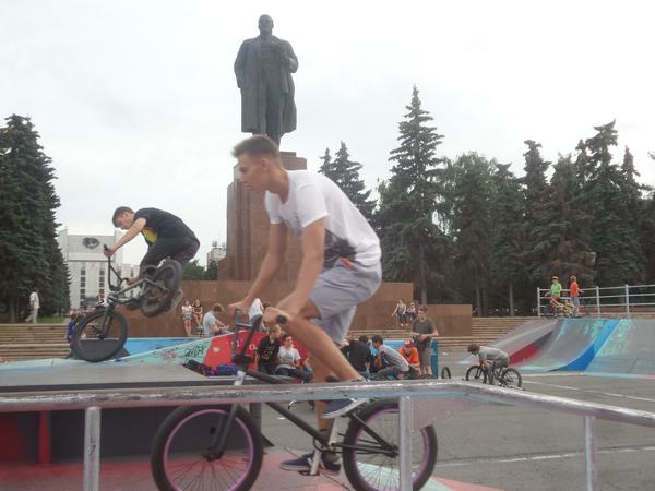 BMX-Fahrer vor einer Lenin-Statue. 