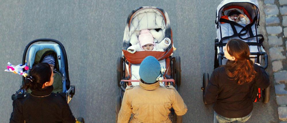 Drei junge Mütter schieben ihre Babys im Kinderwagen bei einem gemeinsamen Spaziergang in Frankfurt am Main. (Archivbild)