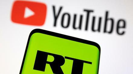 Das Logo des russischen Senders „Russia Today“ (RT) ist vor dem Logo der Streaming-Plattform Youtube zu sehen.