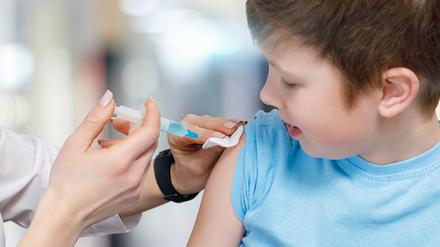 Ein Kind bekommt eine Impfung in den Oberarm.