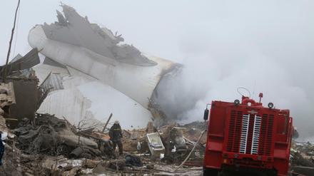 Ein Feuerwehrmann durchsucht die Trümmer des abgestürzten Frachtflugzeugs. 
