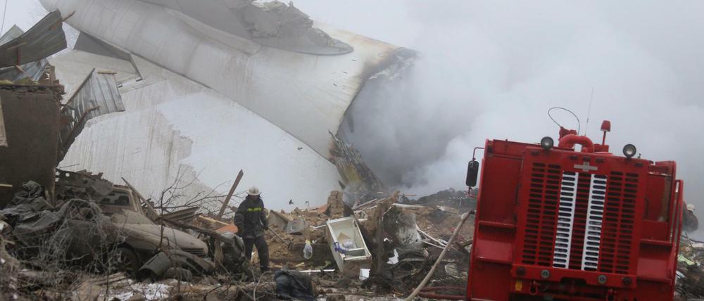 Ein Feuerwehrmann durchsucht die Trümmer des abgestürzten Frachtflugzeugs. 