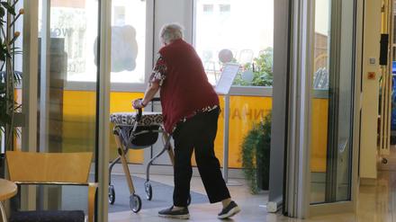 Eine Heimbewohnerin geht mit einem Rollator im Altenzentrum Luisenhaus durch einen Gemeinschaftsbereich.
