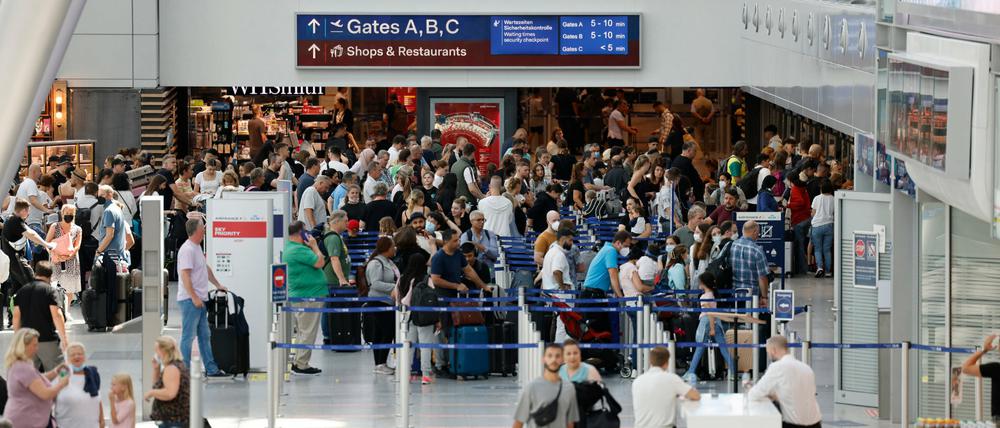 Passagiere stehen an Check-In Schalter der jeweiligen Airlines am Flughafen Düsseldorf an. 