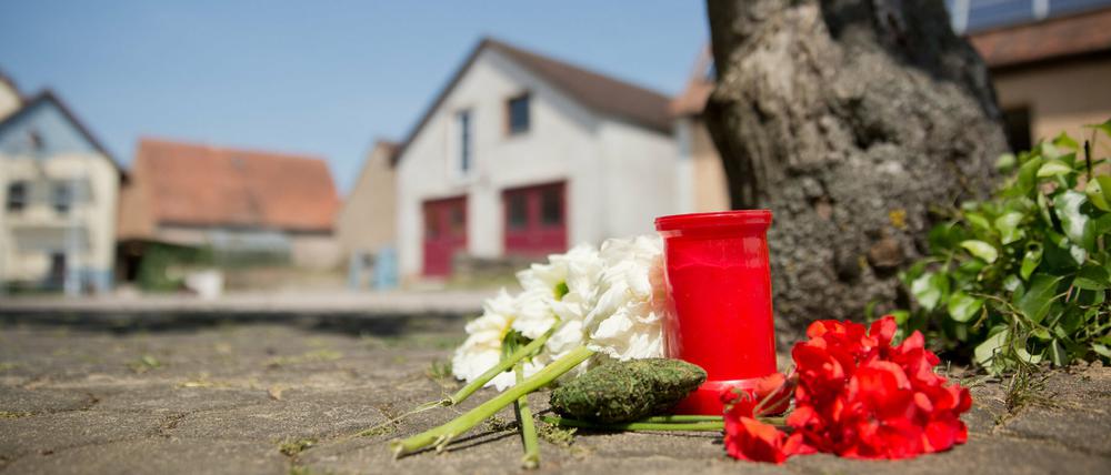 Blumen und eine Kerze liegen am Samstag in Leutershausen an einem Tatort, an dem am Vortag eine Frau erschossen wurde.