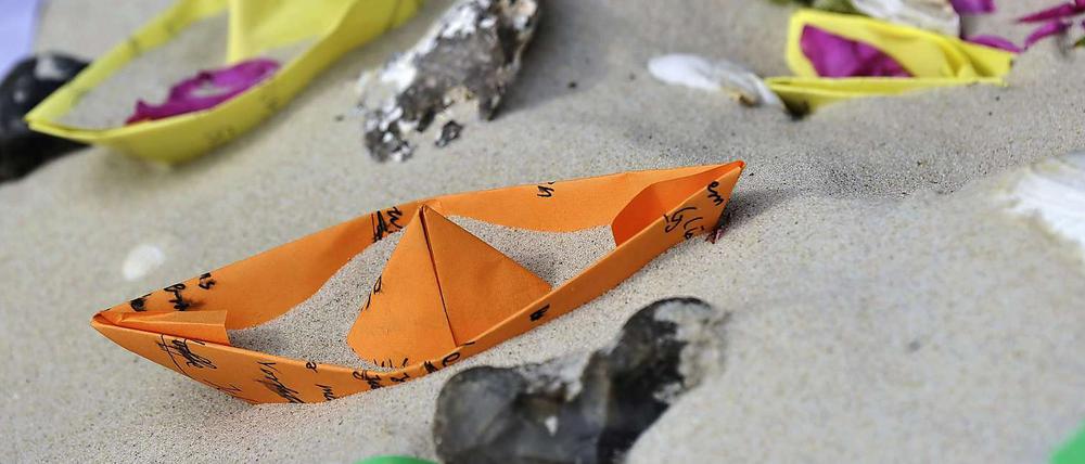 Der Unglücksort nach dem tragischen Unfall: Kinder haben Papierschiffchen und Blumen im Sand abgelegt.