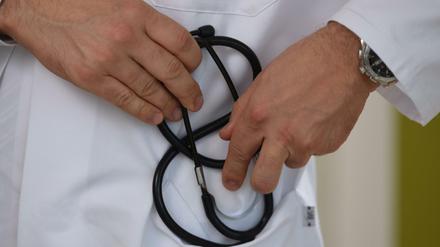 Ein Arzt hält ein Stethoskop in der Hand. 