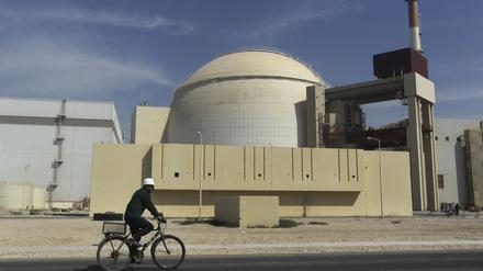 Ein Arbeiter fährt mit seinem Fahrrad vor dem Reaktorgebäude am Atomkraftwerk Buschehr.