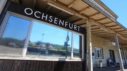 Der Ortsname ist am 19.07.2016 in Ochsenfurt (Bayern) am Bahnhofsgebäude zu lesen. Am Montagabend war ein 17 Jahre alter Afghane, der als Flüchtling in einem Heim in dem Ort gelebt hatte, mit einer Axt und einem Messer auf Fahrgäste in einem Regionalzug bei Würzburg-Heidingsfeld losgegangen. Vier Menschen wurden schwer verletzt, ein weiterer leicht. Die Polizei erschoss den Angreifer als er flüchtete. 