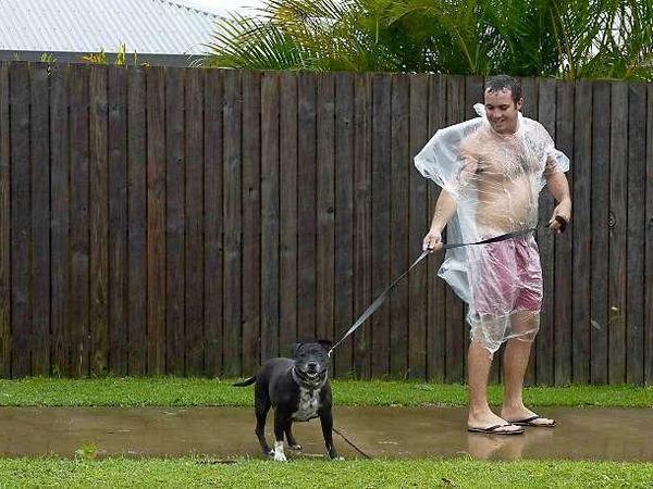 Die Wirbelstürme in Australien erschweren auch das Gassi-Gehen erheblich. Wie diesem Mann am Freitag in Queensland, Australien. 