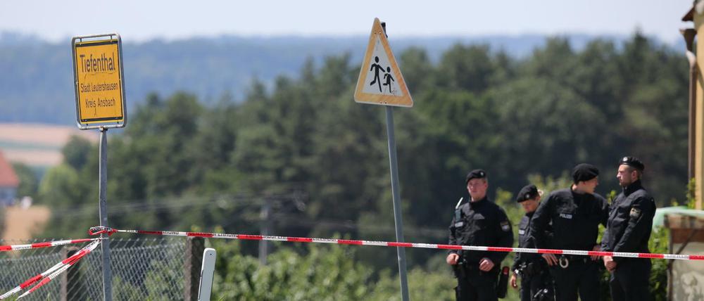 Polizeibeamte stehen am Freitag an einem Tatort in Tiefenthal-Leutershausen bei Ansbach (Bayern). Ein Amokläufer hat dort mindestens zwei Menschen getötet. Die Polizei konnte den mutmaßlichen Täter kurz darauf festnehmen.