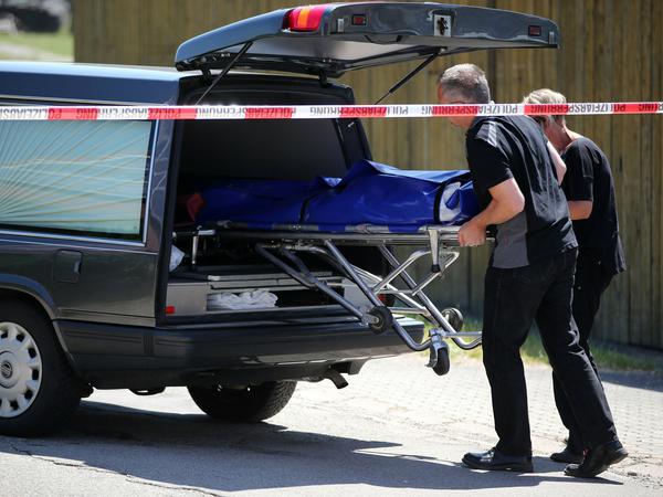 Bestatter schieben am Freitag in Leutershausen bei Ansbach (Bayern) einen Sarg in einen Leichenwagen. Ein Amokläufer hat dort mindestens zwei Menschen getötet. Die Polizei konnte den mutmaßlichen Täter kurz darauf festnehmen.