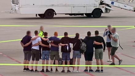 Die acht Männer, die auf Mallorca wegen Brandstiftung in Untersuchungshaft gesessen haben, stehen nach ihrer Ankunft in Deutschland auf dem Flugfeld auf dem Flughafen Münster-Osnabrück zusammen. 