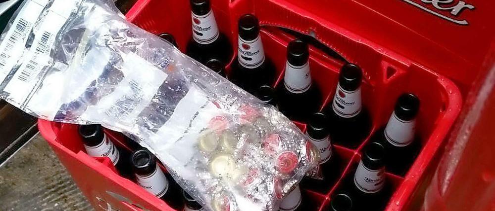 Einbruch in Getränkemarkt in Mülheim: Die Täter rührten das Bier nicht an. Sie hatten es auf die Kronkorken abgesehen. Das Bild der Polizei Essen zeigt die eingesammelten Nieten auf den geöffneten Flaschen. 