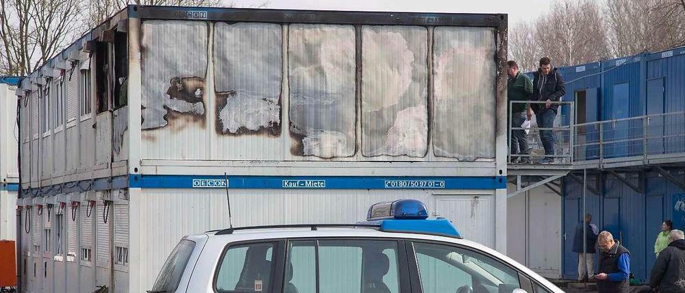 Polizeibeamte untersuchen am Dienstag ausgebrannte Wohncontainer auf dem Gelände der zentralen Aufnahme- und Ausländerbehörde im niedersächsischen Bramsche bei Osnabrück.