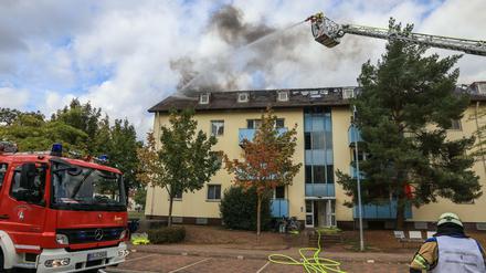 Die Feuerwehr löscht den Dachstuhlbrand in einem Ankerzentrum für Flüchtlinge. Ein Gebäude der Wohneinrichtung musste nach Angaben der Polizei Oberfranken geräumt werden.