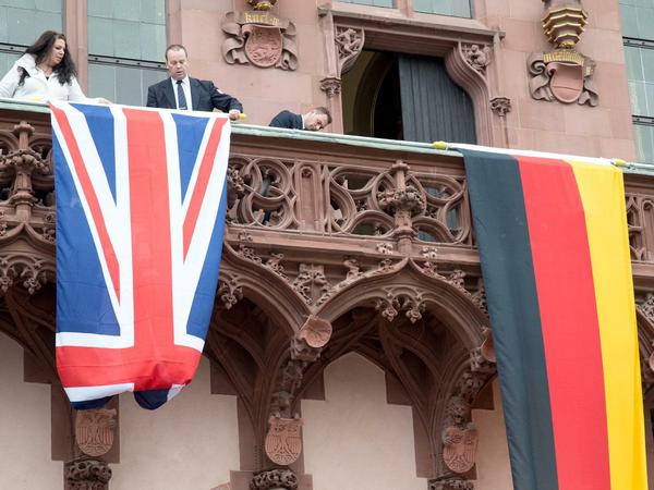 Zur Probe werden die Flaggen von Deutschland (r) und Großbritannien auf dem Balkon des Römer in Frankfurt am Main aufgehängt. Hier soll sich dieQueen dem Publikum zeigen.