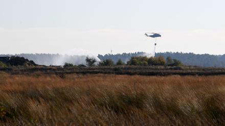 Ein Transporthubschrauber CH-53 der Bundeswehr gibt beim Moorbrand in Meppen Wasser ab.