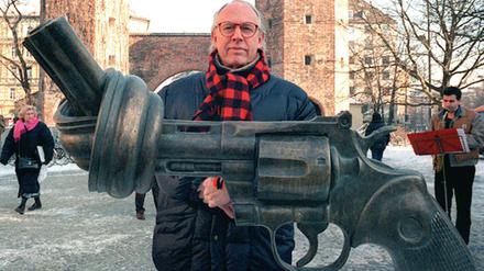 Der schwedische Künstler Carl Fredrik Reuterswärd posiert 1996 hinter seiner Bronzeplastik am Sendlinger Tor in München.