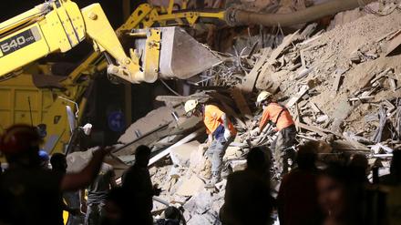 Rettungsteams auchen in den Trümmern eines eingestürzten Gebäudes in Beirut nach Überlebenden.