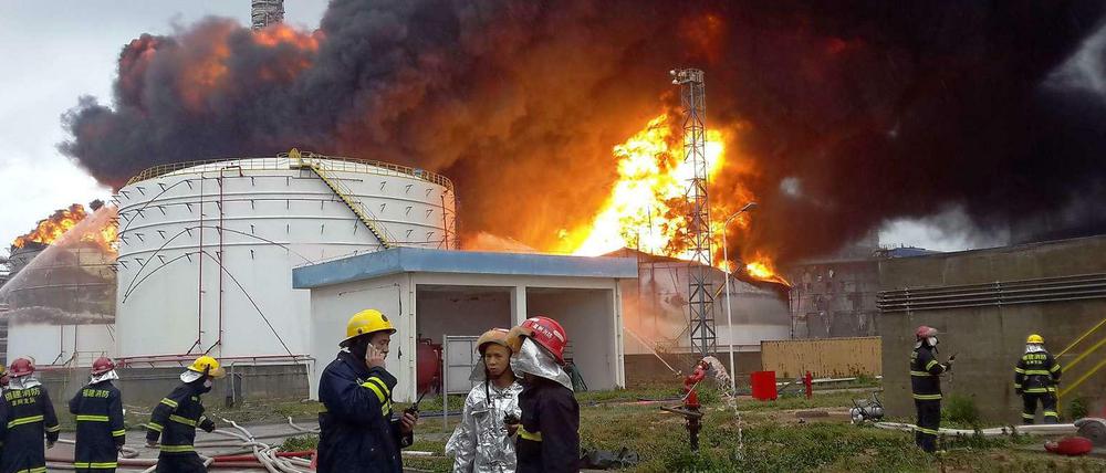 Feuerwehrleute am Dienstag vor der in Brand geratenen Chemiefabrik in Zhangzhou, China. 
