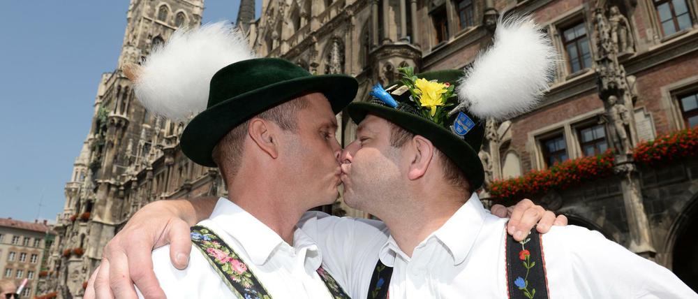Christian (l) und Georg küssen sich beim Christopher Street Day am vor dem Rathaus in München.