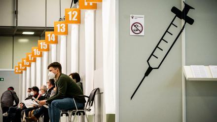 Menschen warten in einem Corona-Impfzentrum auf ihre Impfung.