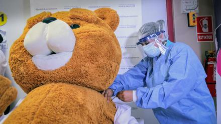 Auf diesem Aufklärungsfoto der peruanischen Regierung wird symbolisch ein Teddybär geimpft.