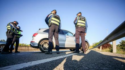 Städtische Polizeibeamte führen im Rahmen der Corona-Maßnahmen eine Autokontrolle auf der Autobahn durch.