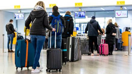 Fluggäste mit dem Reiseziel Mallorca stehen im Flughafen Hannover-Langenhagen am Check-in.