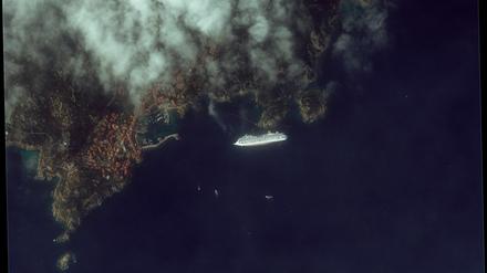 Surreale Szenerie: Die "Costa Concordia" sinkend im blauen Meer.