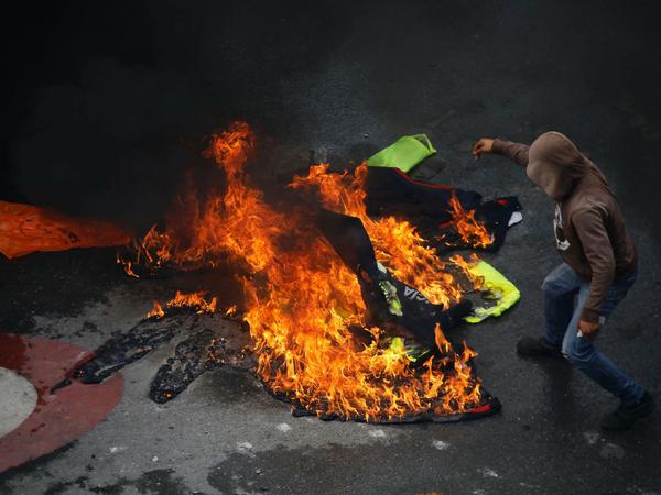 Demonstranten verbrennen in Caracas am Wahlsonntag Polizeiuniformen auf der Straße.