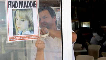 Ein Kellner hängt 2007 ein Bild des vermissten dreijährigen Mädchens Madeleine McCann an das Fenster eines Restaurants.