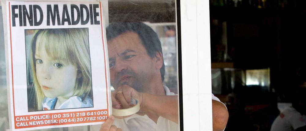 Ein Kellner hängt 2007 ein Bild des vermissten dreijährigen Mädchens Madeleine McCann an das Fenster eines Restaurants.