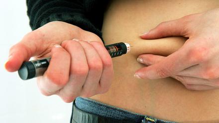 Eine Diabetikerin spritzt sich mit einem Insulin-Pen Insulin.