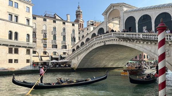 Eine Gondel mit Touristen vor der Rialto-Brücke im Zentrum von Venedig (Symbolbild).
