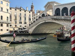 Eine Gondel mit Touristen vor der Rialto-Brücke im Zentrum von Venedig (Symbolbild).