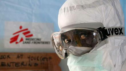 Ein Mitarbeiter von Ärzte ohne Grenzen/Medecins Sans Frontieres (MFS) in Schutzkleidung vor dem Ebola- Zentrum der Hilfsorganisation in Monrovia, Liberia.