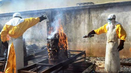 Helfer verbrennen benutzte Schutzkleidung im Ärzte-ohne-Grenzen-Zentrum in Conakry. Die Ebola-Epidemie könnte sich noch erheblich ausweiten.