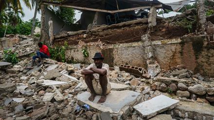 Erdbeben in Haiti: Ein Mann hockt auf den Trümmern des zerstörten Krankenhauses in Fleurant.