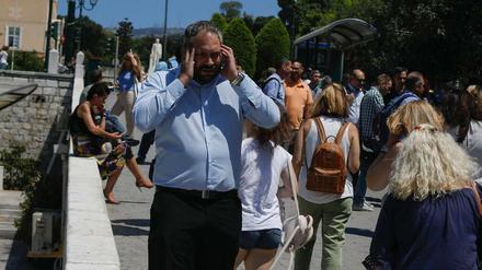Angestellte greifen nach einem starken Erdbeben in Athen zum Handy. 