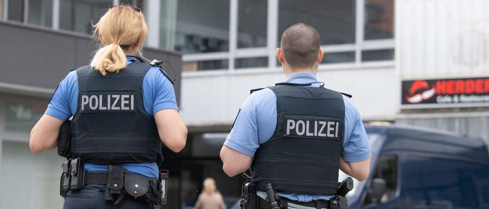 Polizisten stehen vor einem Hochhaus in Hanau, in dem am Vortag zwei Kinder zu Tode gekommen waren.