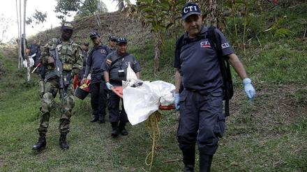 Beamte in Kolumbien tragen eine Leiche auf einer Trage. Ein Mann soll 25 Menschen umgebracht haben. 