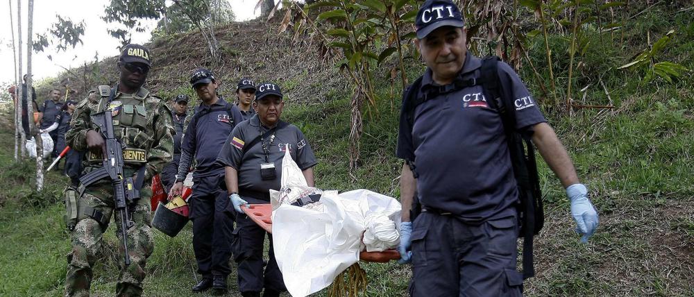 Beamte in Kolumbien tragen eine Leiche auf einer Trage. Ein Mann soll 25 Menschen umgebracht haben. 
